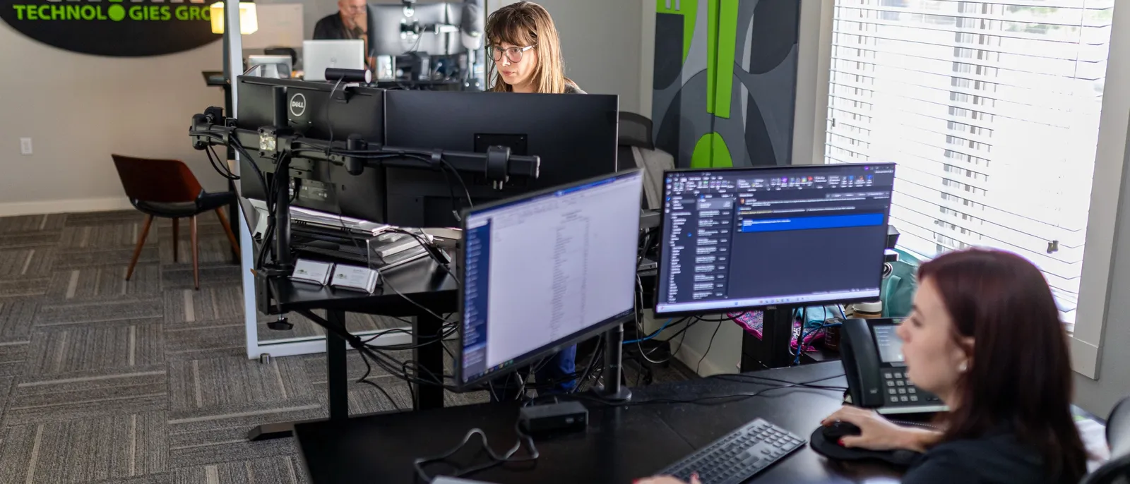 Lauren and a teammate at their workstations in the thinkVoIP office