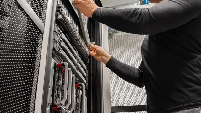 Technician working on server rack equipment in a data closet